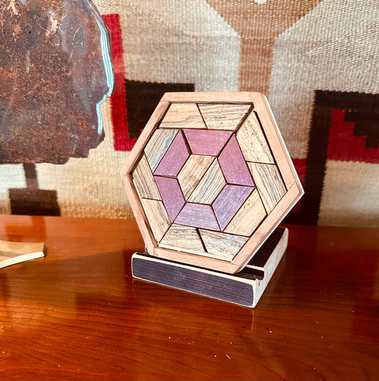 1J.  2 species Challenge puzzle.   Only comes in rare and costly exotic hardwoods such as Desert Ironwood and Purpleheart.   Follow word challenges to create beautiful designs to display. For example, “create a puzzle with three separate hexagons.”